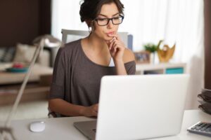 Mulher vendo quanto custa um site em seu notebook
